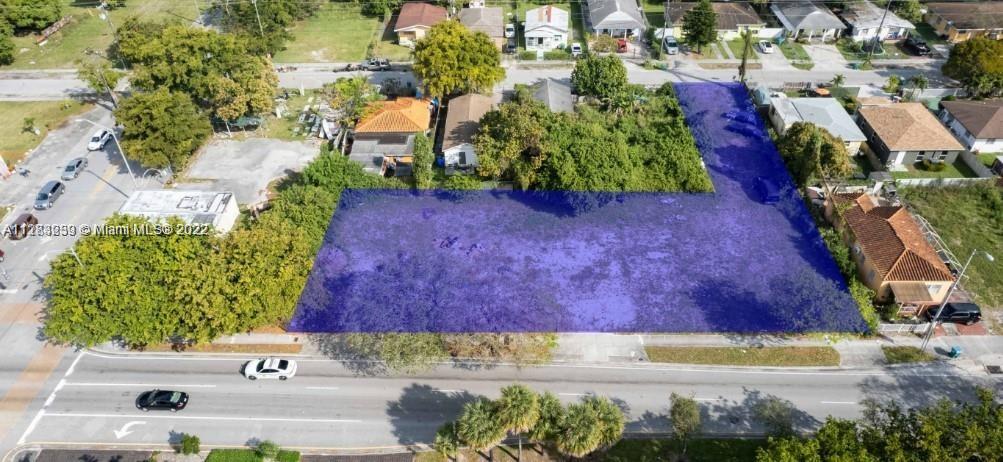 An aerial view shows a vacant, L-shaped lot highlighted in blue within a residential neighborhood — 1765 NW 62nd St, Miami FL 33147, MIAMI, FL