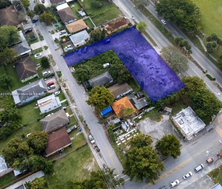 An aerial view shows a vacant, L-shaped lot highlighted in purple next to residential houses — 1765 NW 62nd St, Miami FL 33147, MIAMI, FL