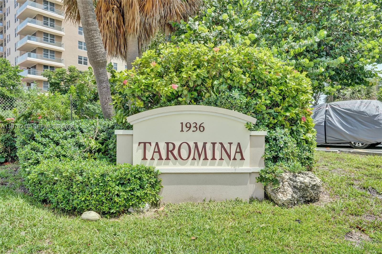 A beige monument sign reading Taromina sits in front of a large green bush — 1936 S Ocean # 20D, Hallandale Beach FL 33009, HALLANDALE BEACH, FL