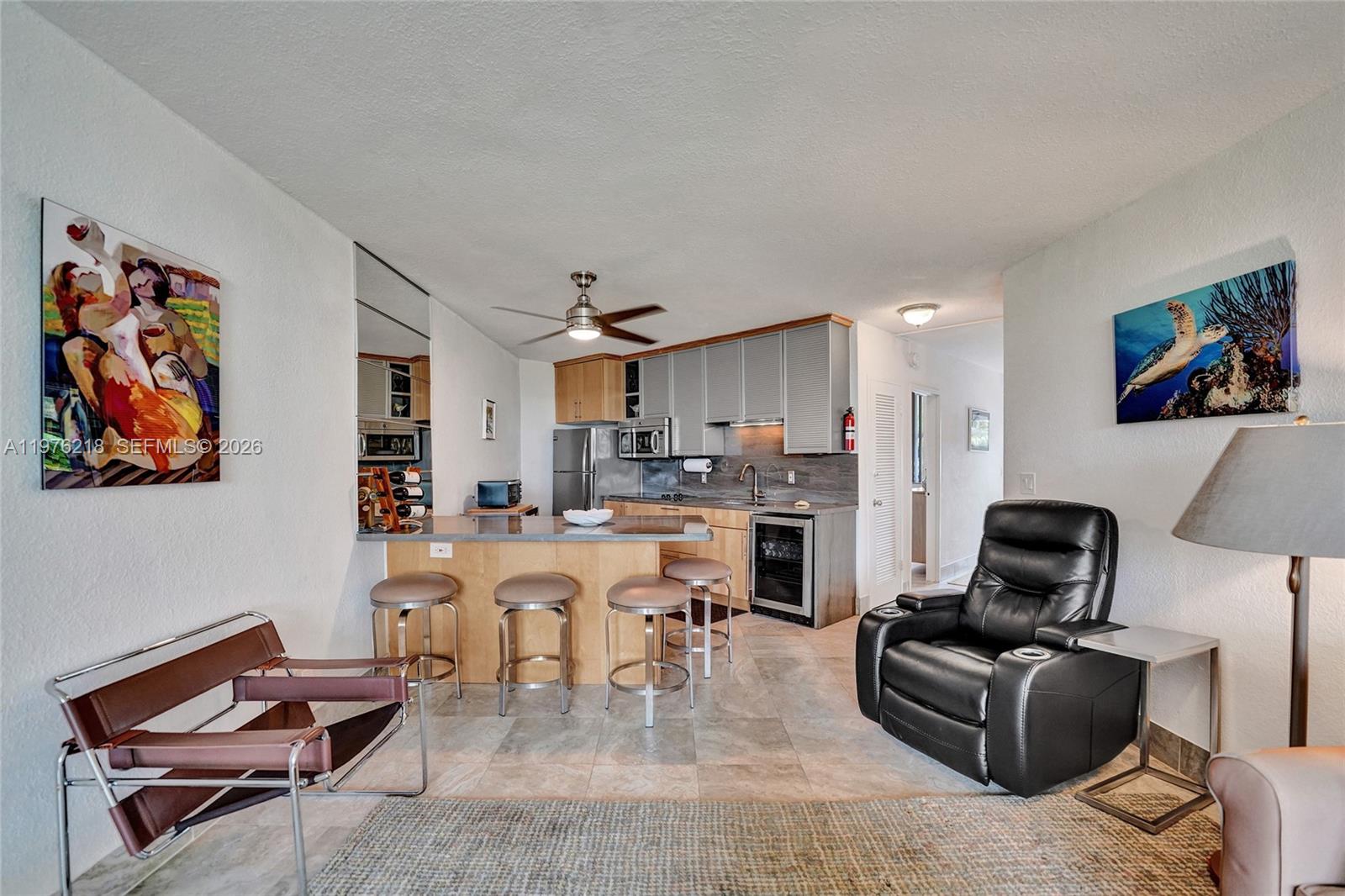 A kitchen with light wood cabinets and a breakfast bar opens into a living area — 1936 S Ocean # 20D, Hallandale Beach FL 33009, HALLANDALE BEACH, FL