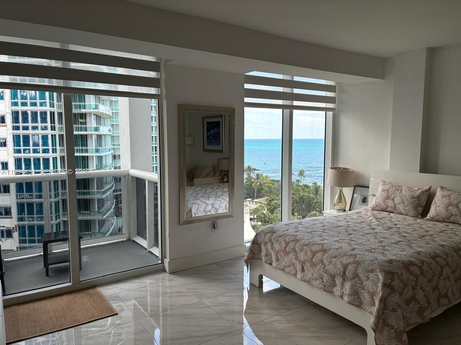 A bedroom with tile floors, a bed, and floor-to-ceiling windows overlooking the ocean — 10275 Collins Ave # 1004, Bal Harbour FL 33154, BAL HARBOUR, FL