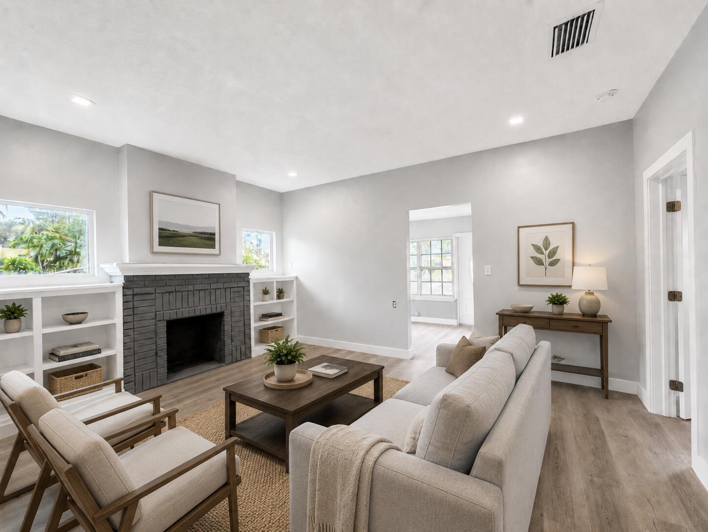 A living room features a gray brick fireplace, light wood floors, and neutral-toned furniture — 1905 Monroe Street, Hollywood FL 33020, HOLLYWOOD, FL