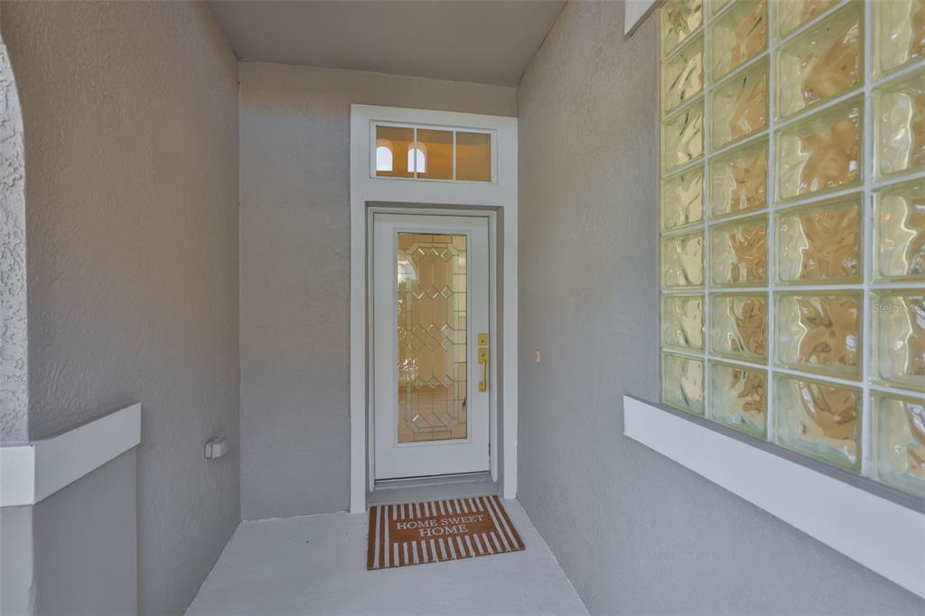 A front entryway features a white door with a glass insert and a glass block window — 448 NOBLE FAIRE DRIVE, SUN CITY CENTER, FL