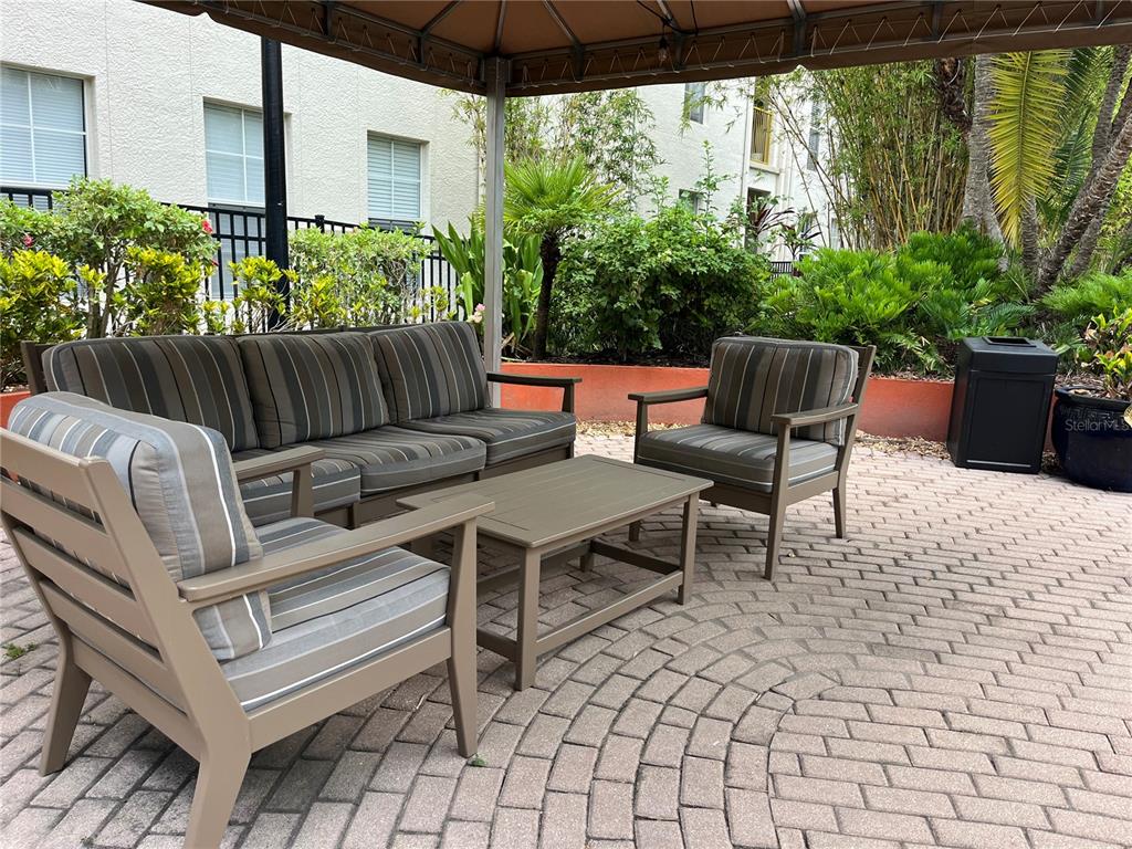 A brick patio features a built-in stainless steel grill, a small table, and two chairs — 501 S MOODY AVENUE UNIT 1119B, TAMPA, FL