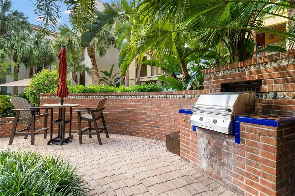 A paved walkway leads through a black metal gate toward a swimming pool area — 501 S MOODY AVENUE UNIT 1119B, TAMPA, FL