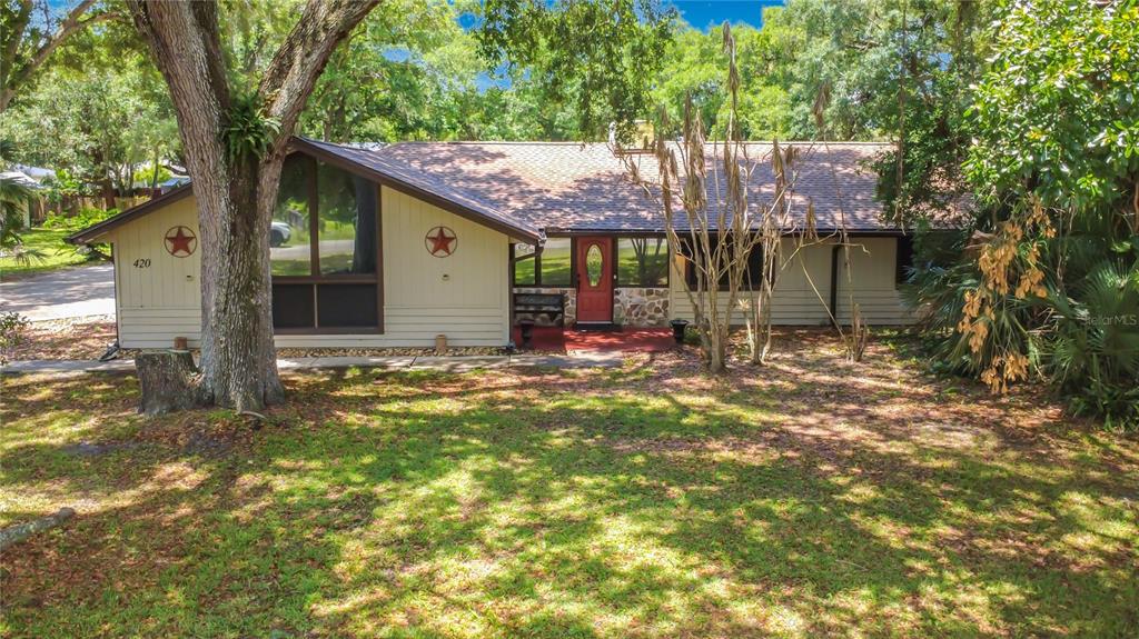 A single-story house with light siding, a red front door, and two decorative metal stars — 420 NINA ROAD NE, PALM BAY, FL