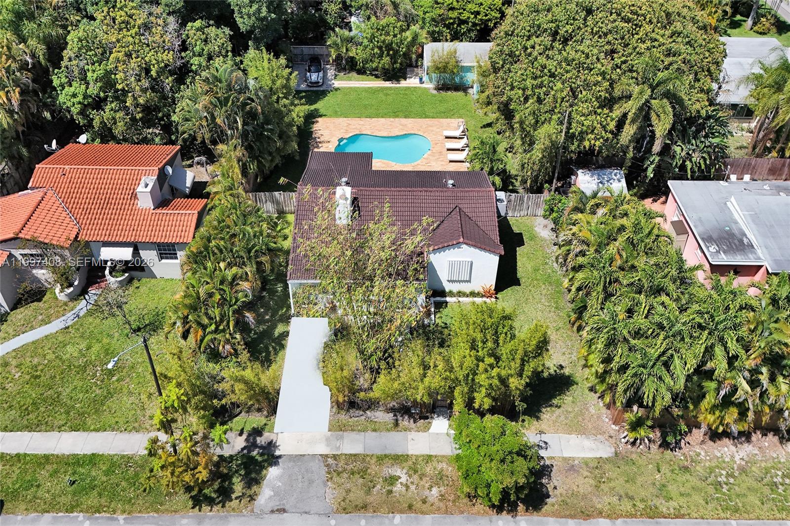 An aerial view shows a house with a brown tiled roof, pool, and backyard — 1515 Dewey St, Hollywood FL 33020, HOLLYWOOD, FL