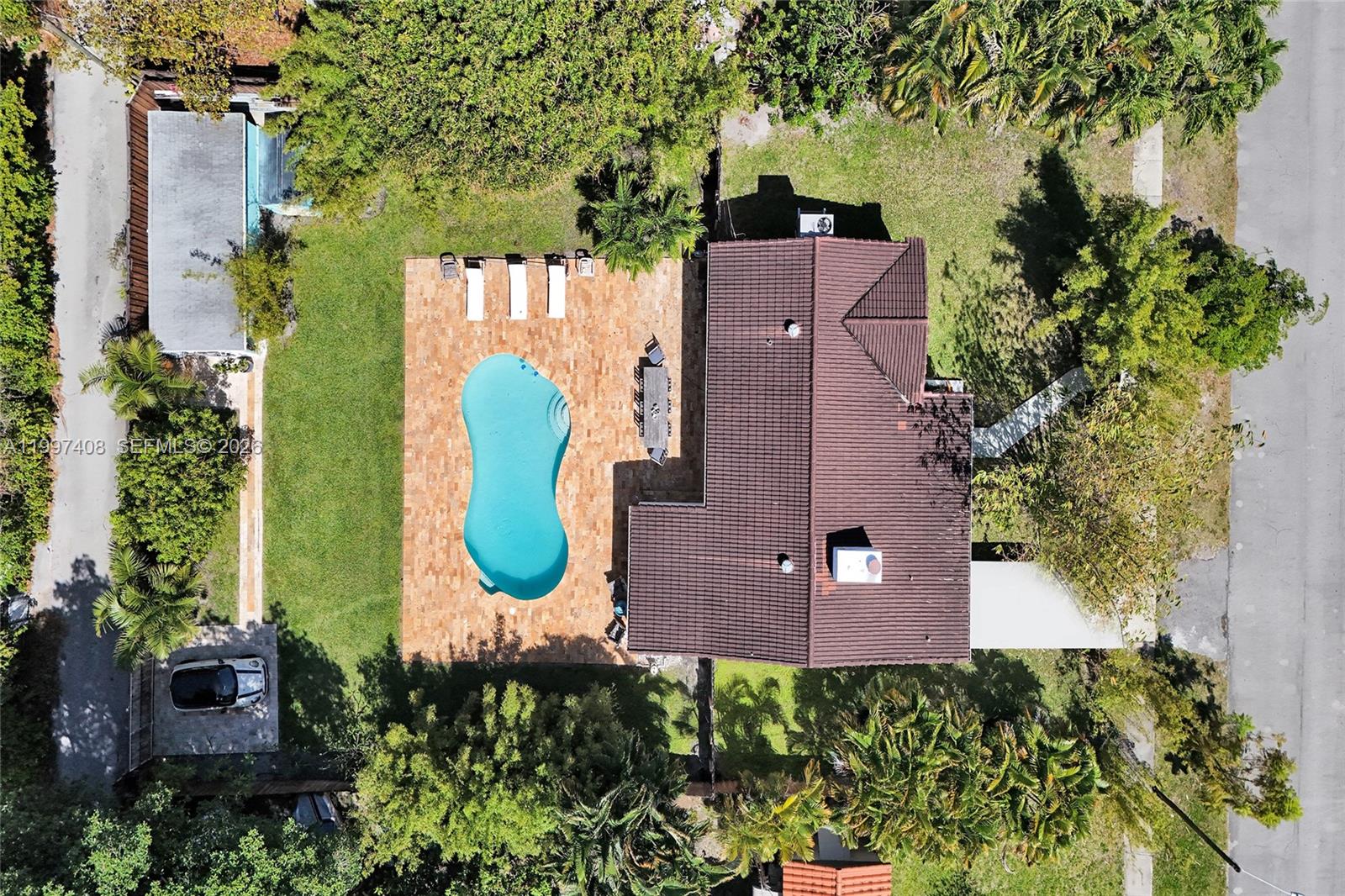 An aerial view shows a house with a brown roof, a pool, and a patio — 1515 Dewey St, Hollywood FL 33020, HOLLYWOOD, FL