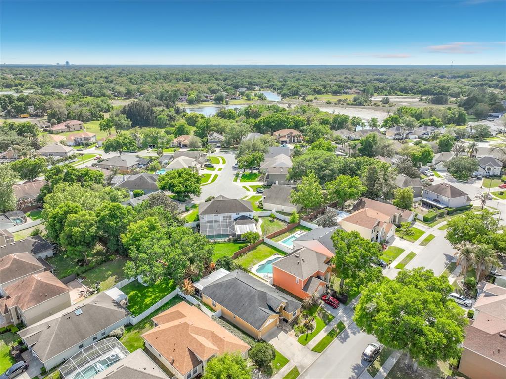An aerial view shows a suburban neighborhood with houses, swimming pools, and surrounding green space — 233 HANGING MOSS CIRCLE, LAKE MARY, FL