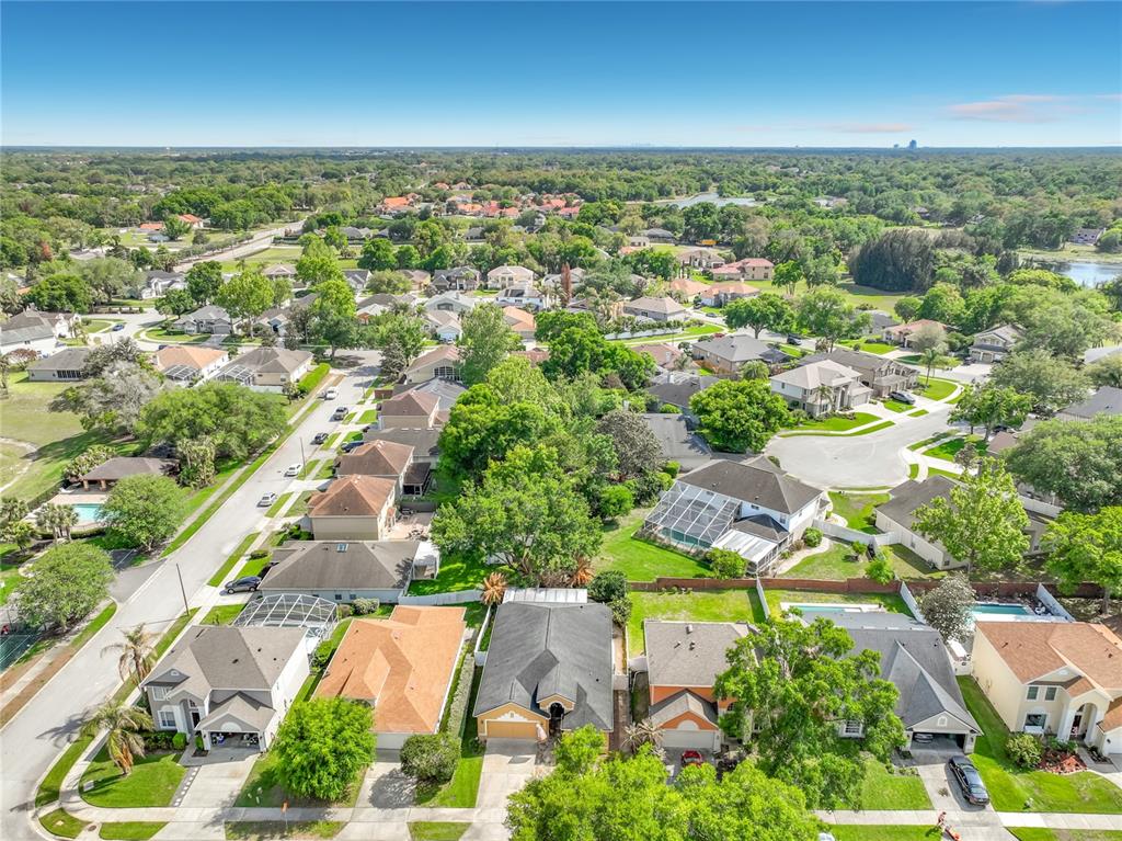 An aerial view shows a suburban neighborhood with single-family homes, green trees, and paved streets — 233 HANGING MOSS CIRCLE, LAKE MARY, FL