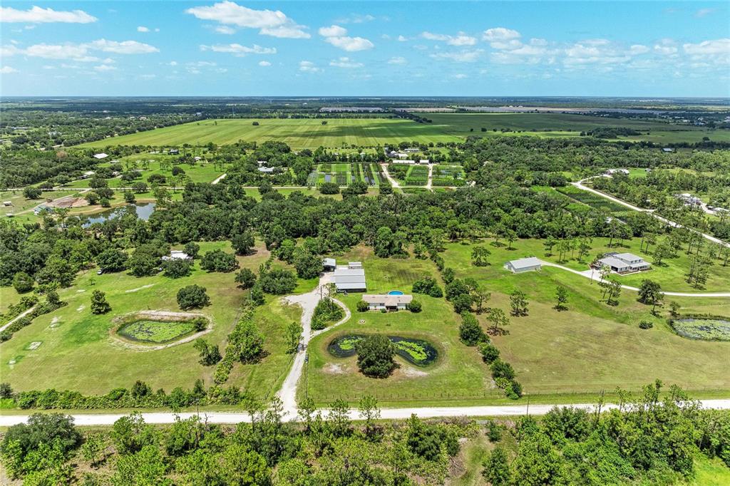 A single-story manufactured home with a screened-in porch sits on a large grassy lawn — 23715 73RD AVENUE E, MYAKKA CITY, FL