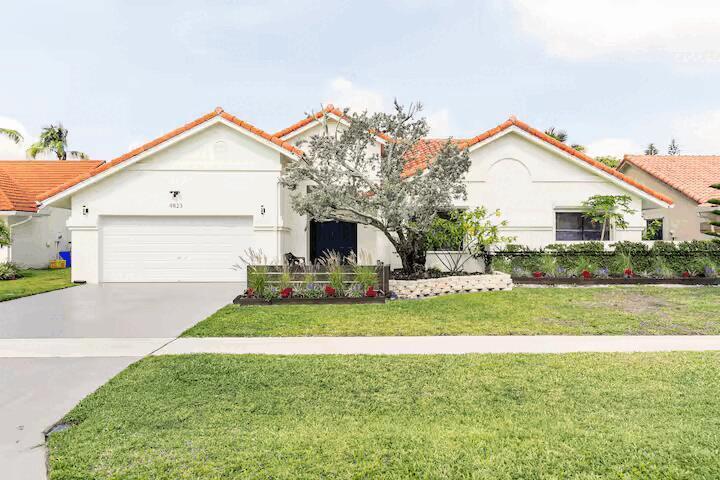 A single-story house with a white stucco exterior, orange tile roof, and a two-car garage — 9823 Sun Pointe Drive, Boynton Beach FL 33437, BOYNTON BEACH, FL