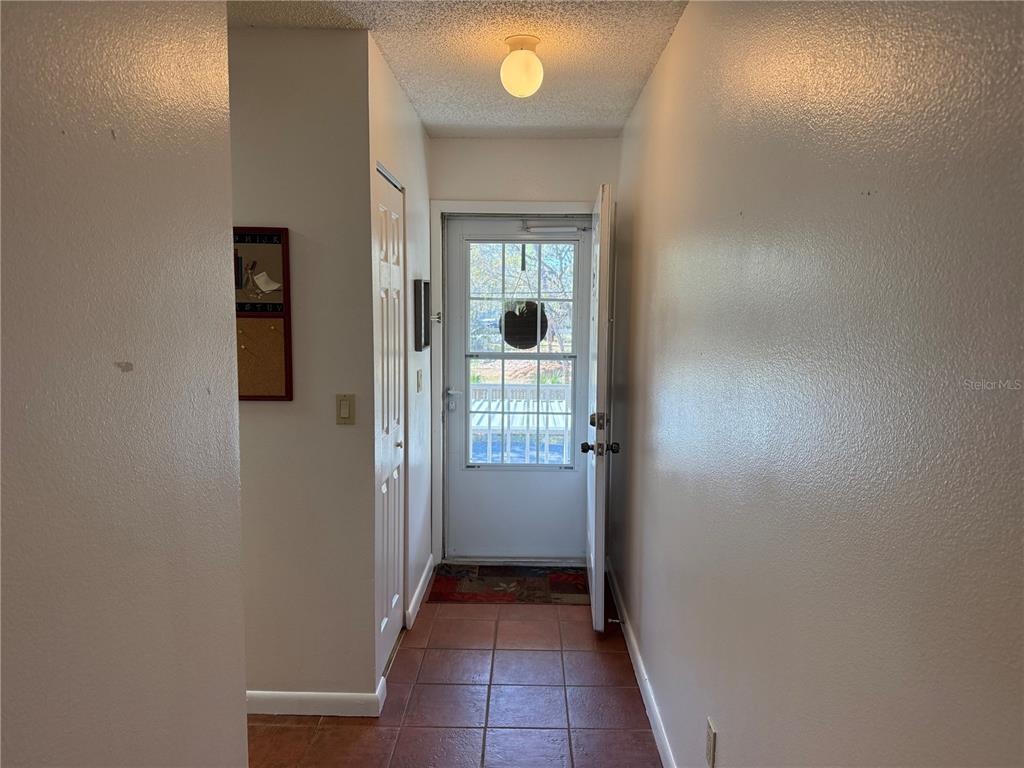 A tiled entryway features a white door with a glass insert and a ceiling light fixture — 6519 SPRING FLOWER DRIVE UNIT 22, NEW PORT RICHEY, FL