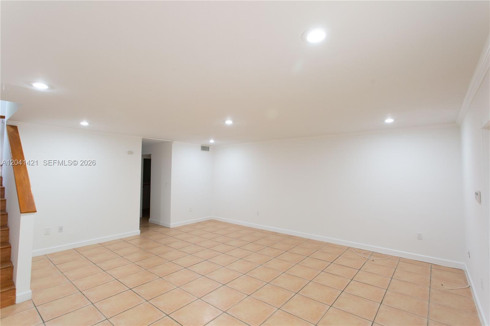 An empty room features white walls, recessed lighting, and light-colored square floor tiles — 2919 Virginia St, Miami FL 33133, MIAMI, FL