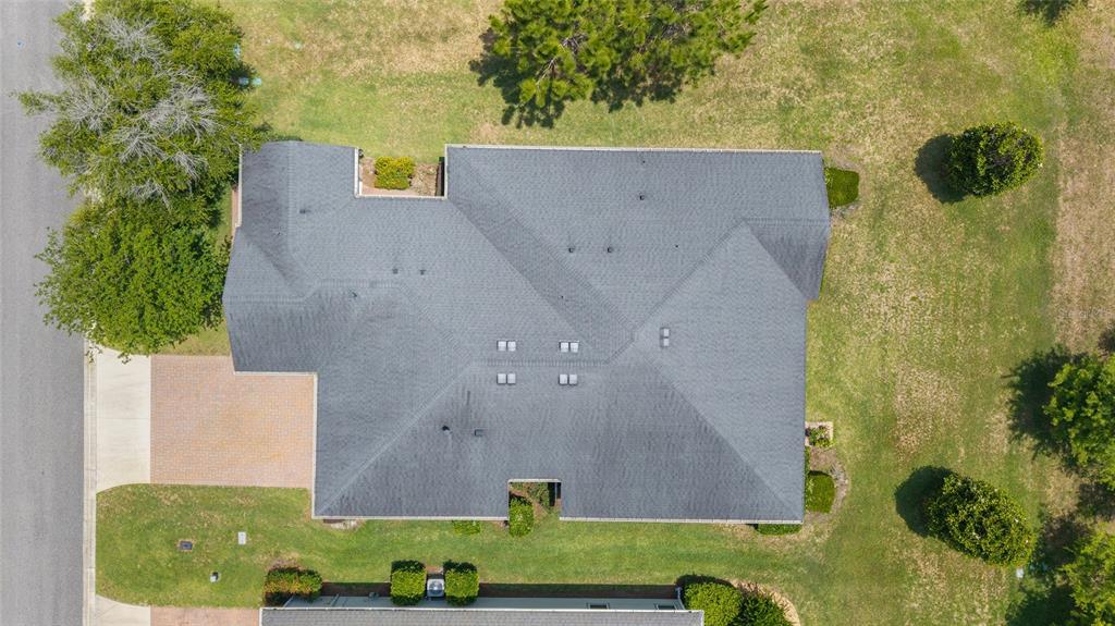 An aerial view shows the gray shingled roof of a house surrounded by green grass — 3862 NW 49TH COURT, OCALA, FL