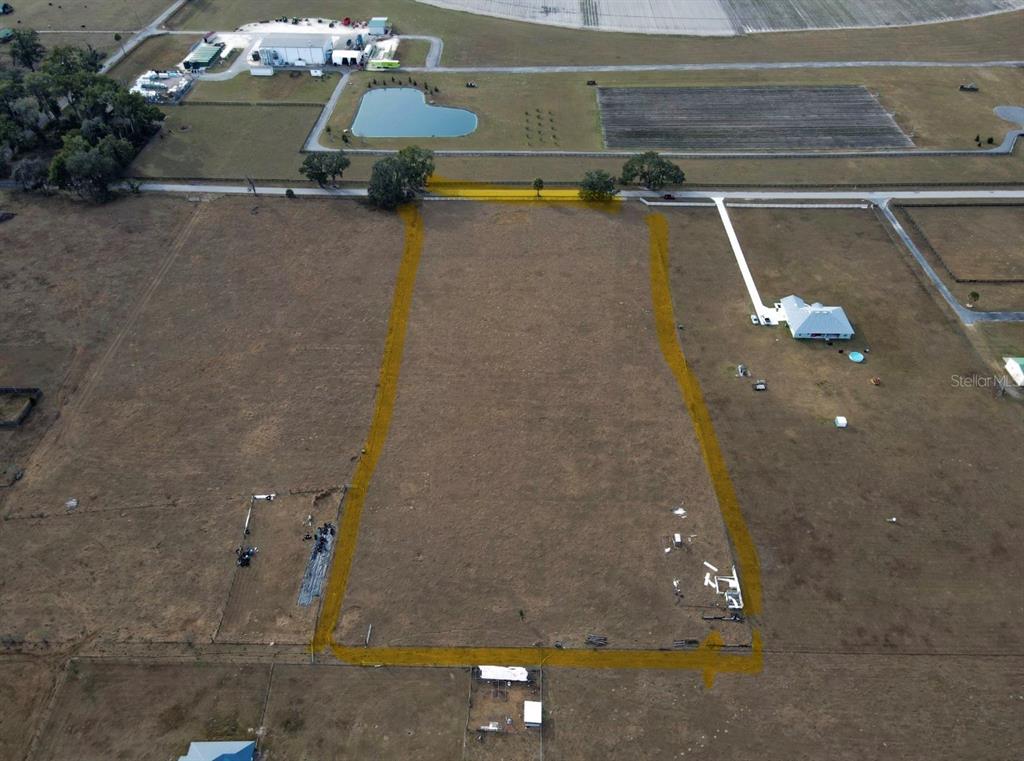 An aerial view shows a rectangular plot of land outlined in yellow in a rural area — 191 CR-482N, LAKE PANASOFFKEE, FL