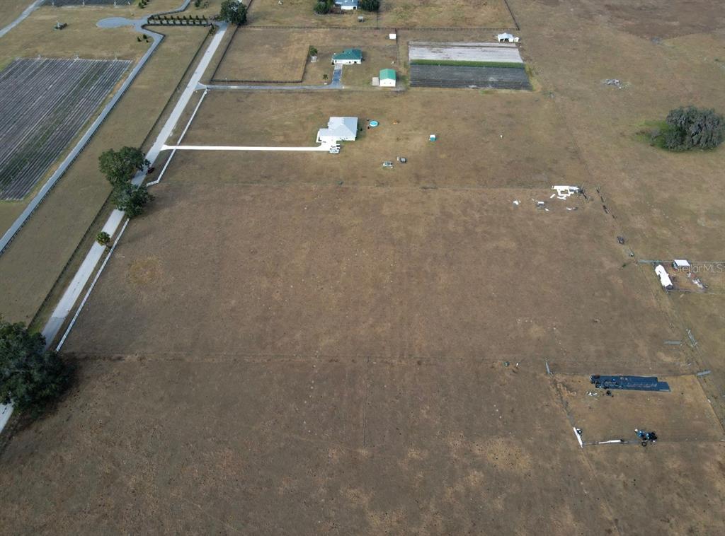 An aerial view shows a large, open pasture with a house and several outbuildings — 191 CR-482N, LAKE PANASOFFKEE, FL
