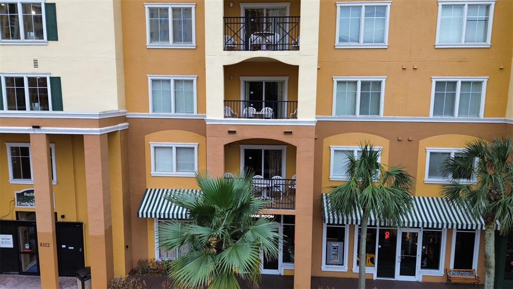 An exterior view of a multi-story apartment building with balconies and a ground-level game room — 8112 POINCIANA BOULEVARD UNIT 1206, ORLANDO, FL