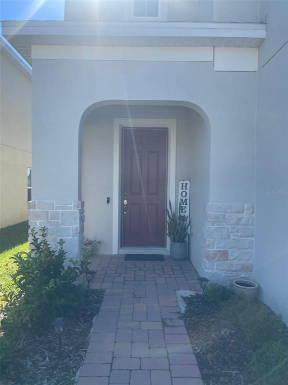 A front entryway features a red door, stone accents, and a brick paver walkway — 5014 ROYAL POINT AVENUE, KISSIMMEE, FL