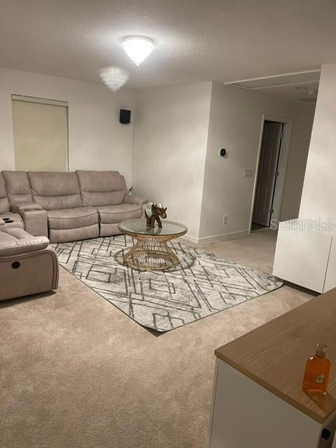 A living room features a beige sectional sofa, a geometric area rug, and a glass-topped table — 5014 ROYAL POINT AVENUE, KISSIMMEE, FL