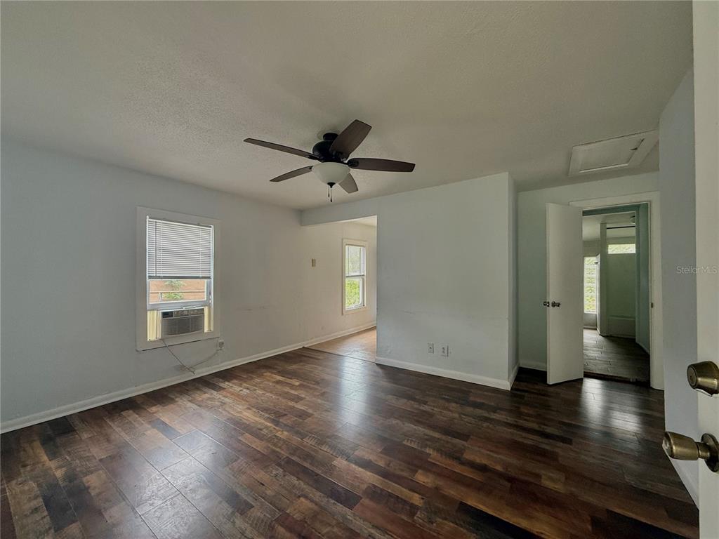 A living room features dark wood-look flooring, light blue walls, and a ceiling fan — 7581 S MYERS POINT, FLORAL CITY, FL