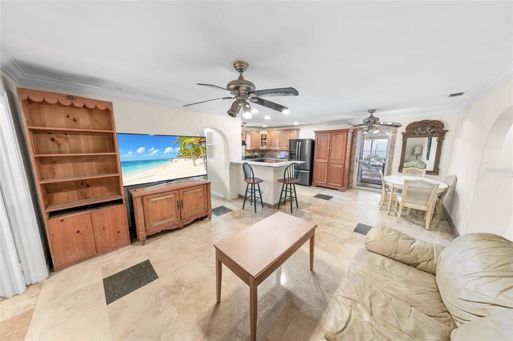 A living room with tile floors, a ceiling fan, a television, and an open kitchen — 332 FLETCHER AVENUE, DAYTONA BEACH, FL