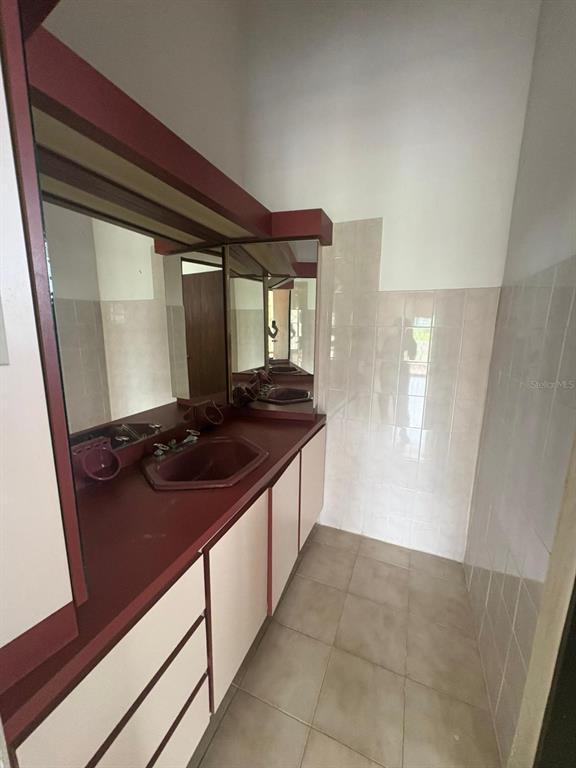 A bathroom features a maroon countertop, a matching sink, and light-colored cabinets — URB EL MADRIGAL MARGINAL NORTE, PONCE, PR