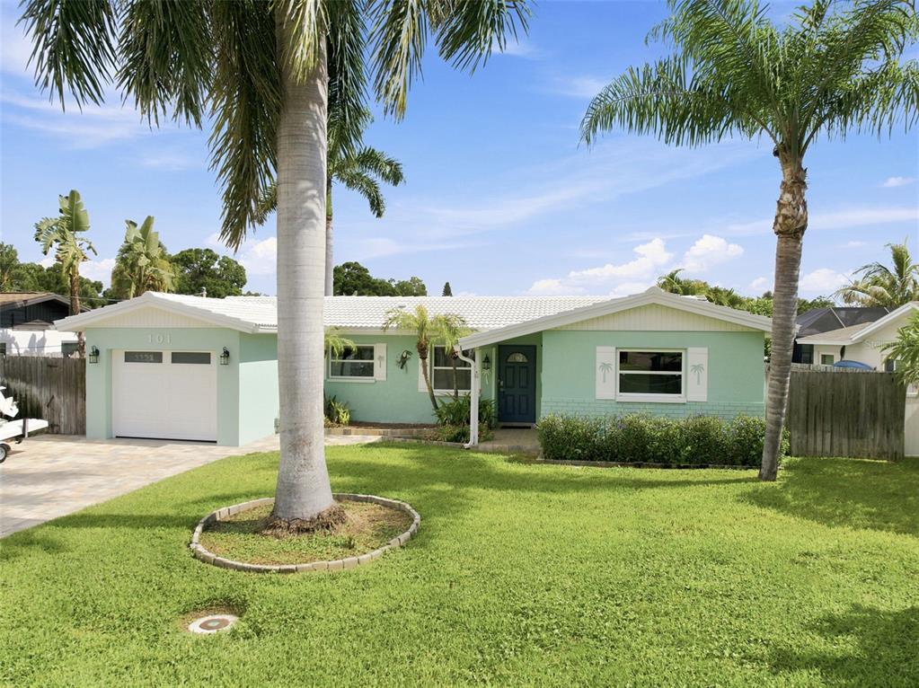 A light green single-story house with a white roof and palm trees in the yard — 101 92ND AVENUE N, ST PETERSBURG, FL