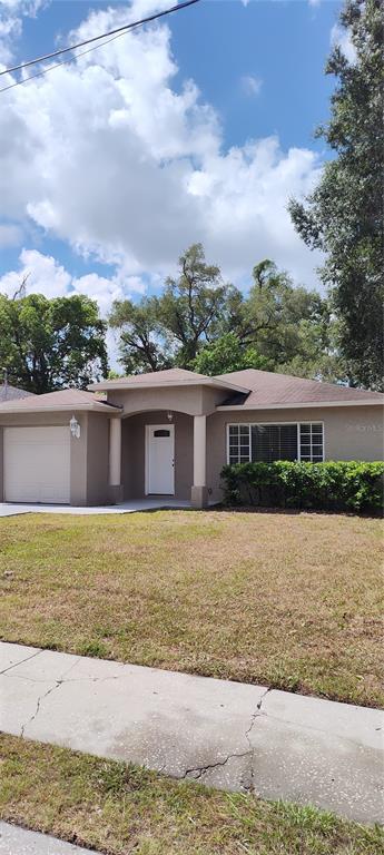 A single-story house with a beige exterior, a one-car garage, and a front porch — 3103 E 25TH AVENUE, TAMPA, FL