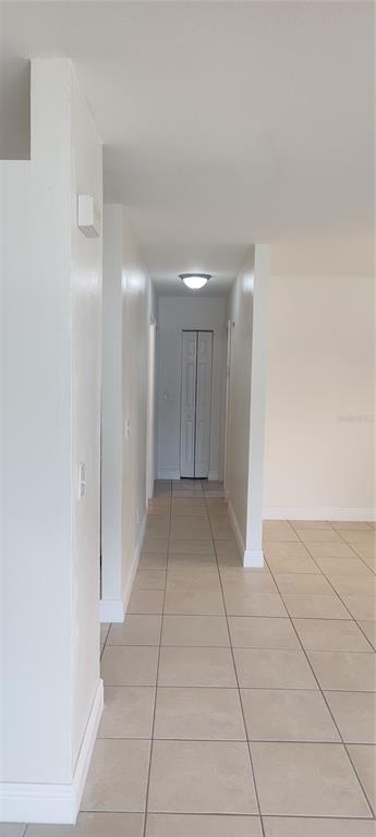 An empty room with beige walls, tile flooring, and two windows with white blinds — 3103 E 25TH AVENUE, TAMPA, FL