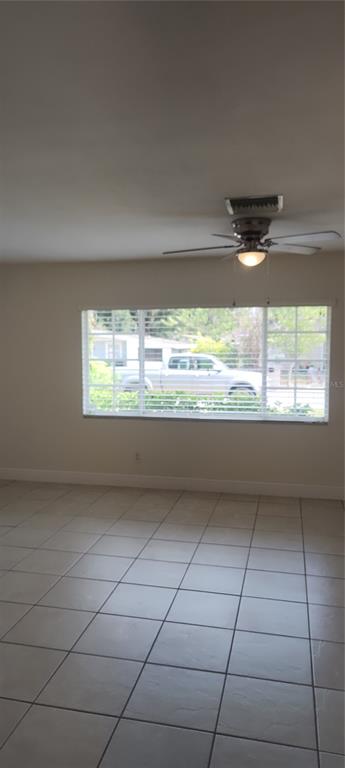 A dining area features tile flooring, a white chandelier, and a window with blinds — 3103 E 25TH AVENUE, TAMPA, FL