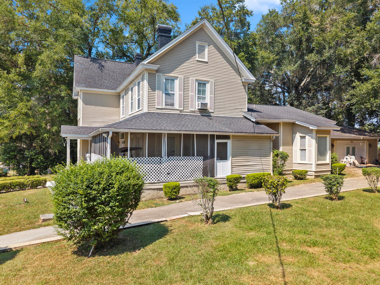 A two-story beige house with a screened-in porch and a detached garage — 618 W Washington Street, FL 32351, FL