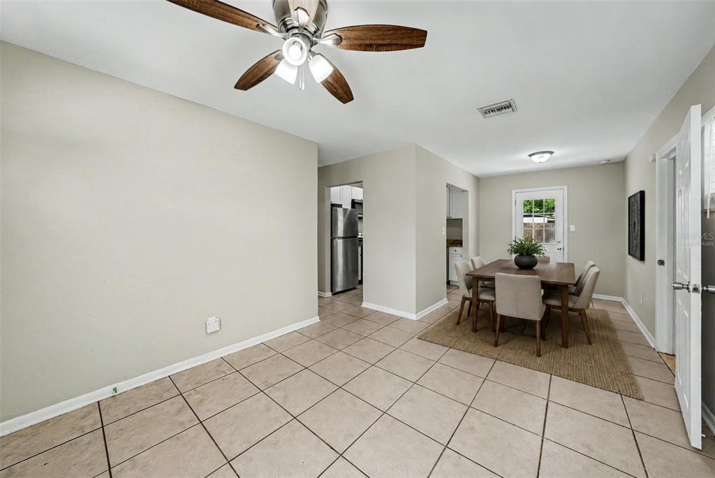 A dining area with tile flooring, a ceiling fan, and a wooden table with chairs — 10209 N 28TH STREET, TAMPA, FL