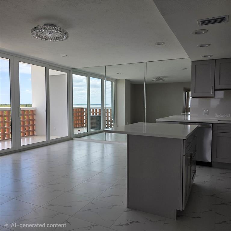 A kitchen with a center island and white marble-look tile floors opens to a balcony — 4015 BAYSHORE BOULEVARD UNIT 7F, TAMPA, FL