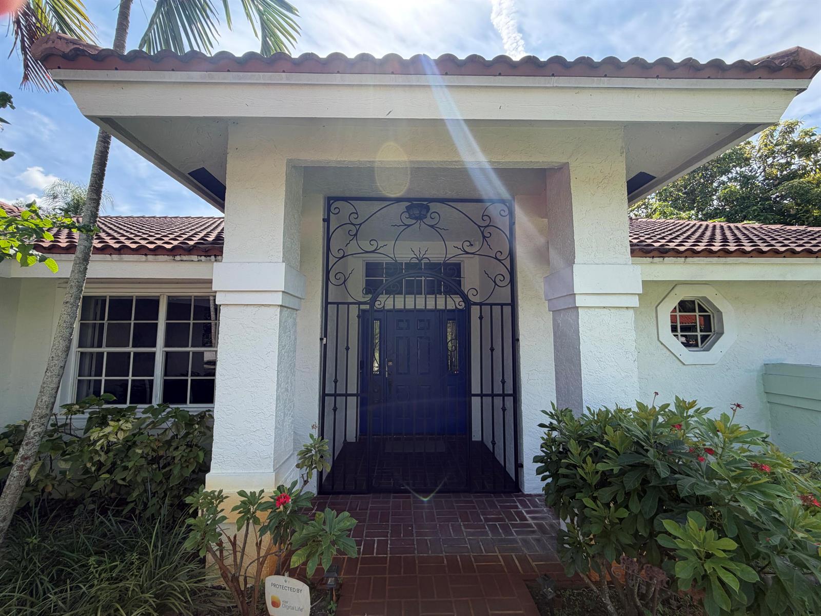 The front entrance of a house features a decorative metal gate and a tiled roof — 1770 Emilio Lane, Palm Springs FL 33406, PALM SPRINGS, FL