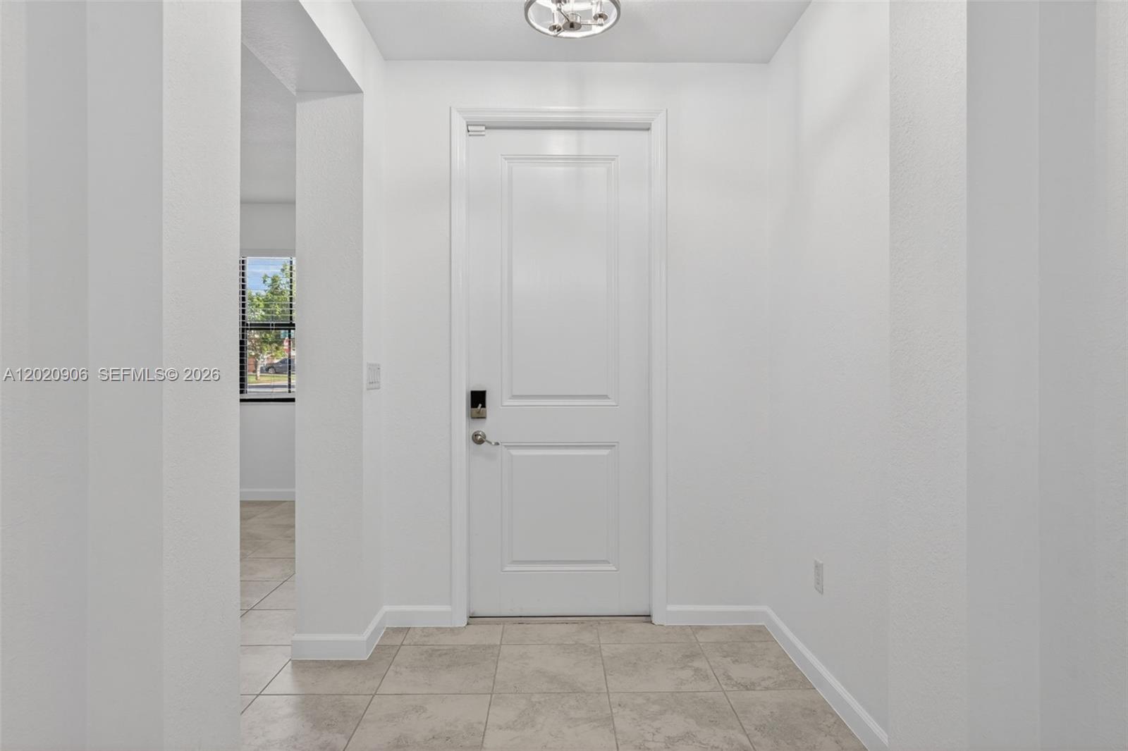 A white front door with a smart lock stands in a tiled entryway — 2371 SE 1st Ct, Homestead FL 33033, HOMESTEAD, FL