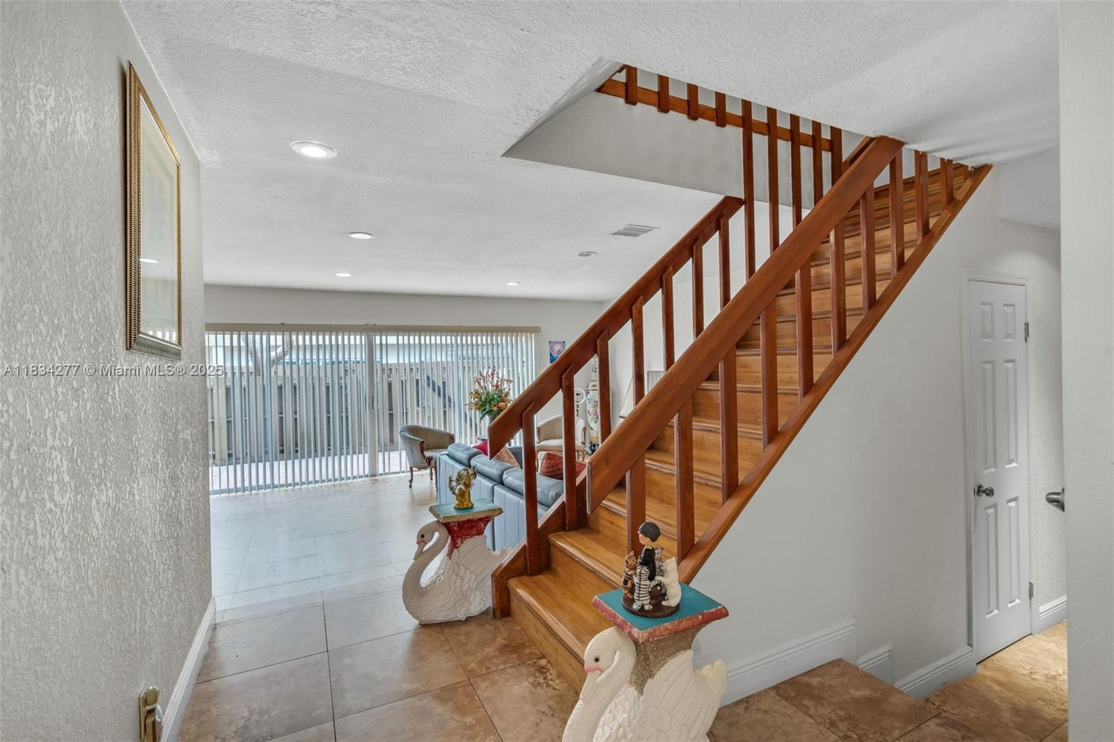 A wooden staircase with a railing stands in a tiled entryway next to a living area — 8256 NW 9th Ct # 2, Plantation FL 33324, PLANTATION, FL