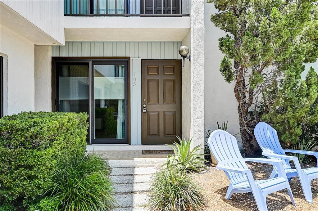A brown front door and sliding glass door are visible at the entrance of a residence — 722 S BLVD OF THE PRESIDENTS UNIT 105, SARASOTA, FL