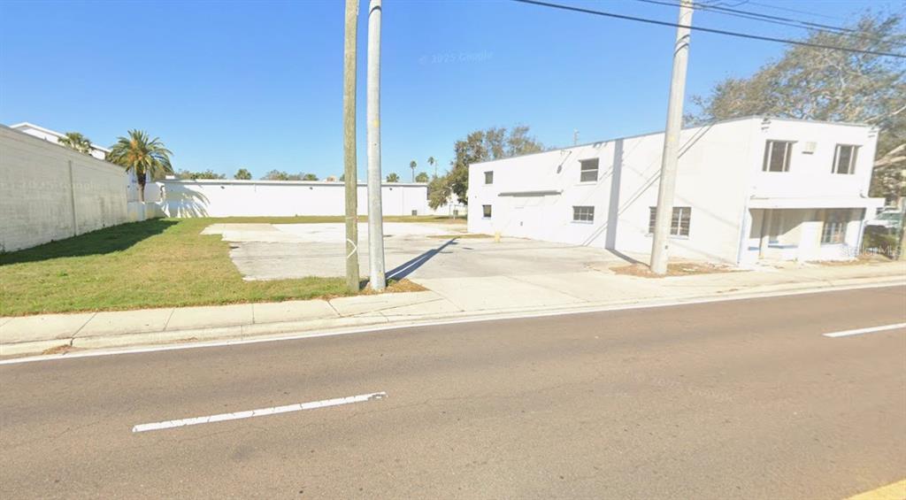 A vacant lot sits between two white commercial buildings along a paved street — 504 S MYRTLE AVENUE, CLEARWATER, FL