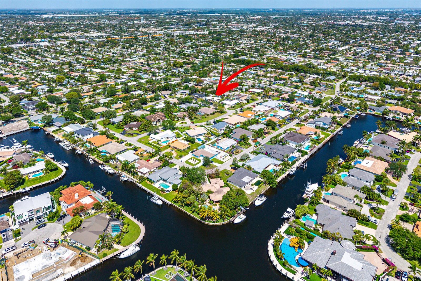 An aerial view of a residential neighborhood with houses along canals and a red arrow — 2741 NE 52nd Street, Lighthouse Point FL 33064, LIGHTHOUSE POINT, FL