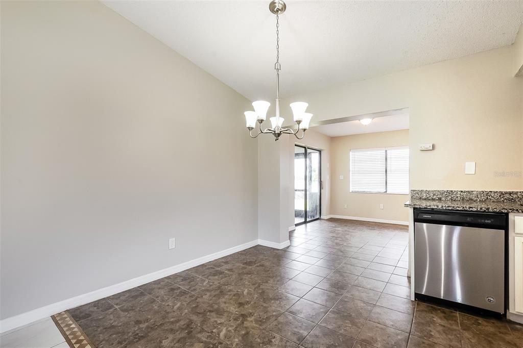 A dining area with tile flooring, a chandelier, and a view into an adjacent room — 2072 DUMAS DRIVE, DELTONA, FL
