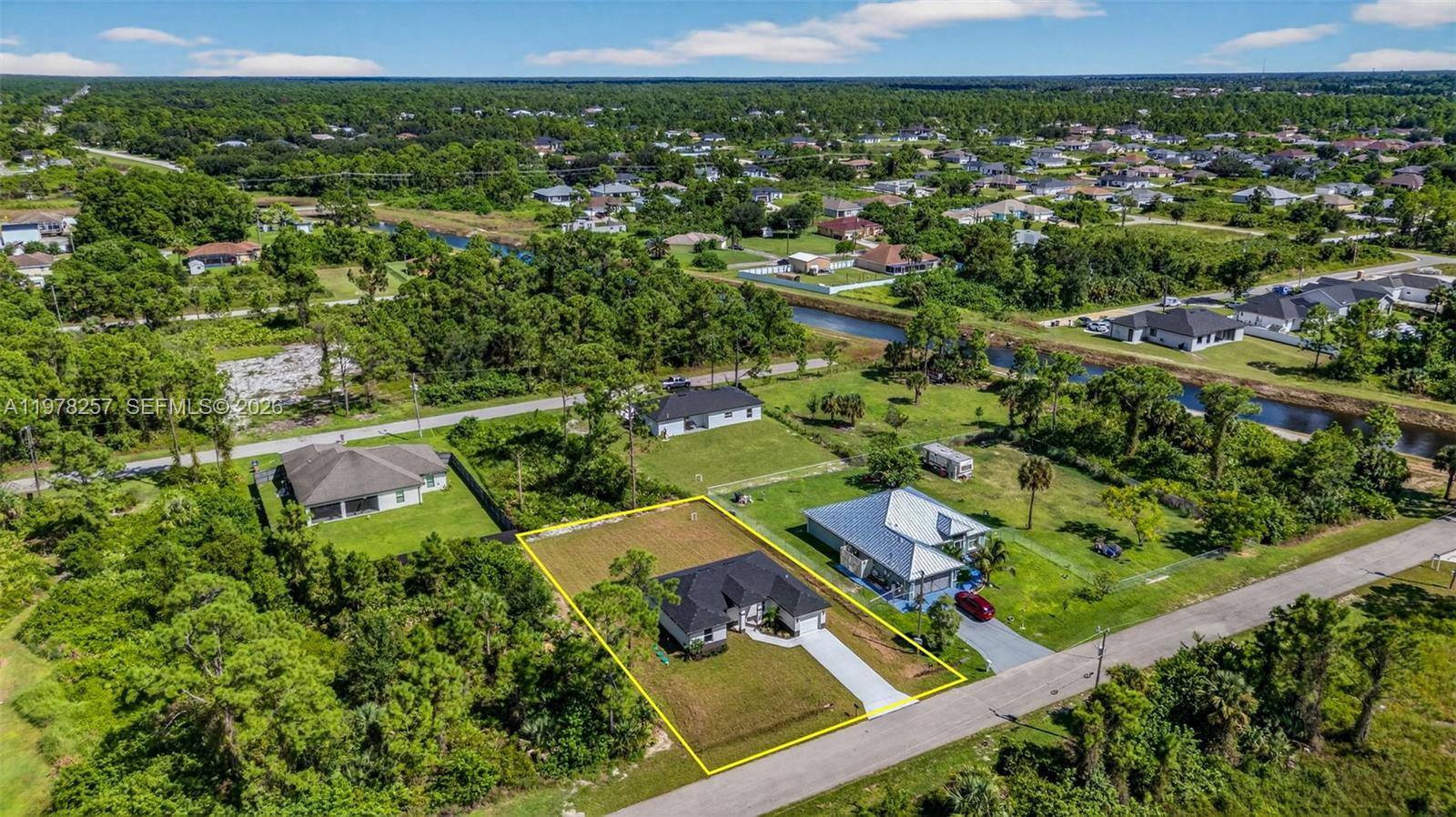 An aerial view shows a single-story house with a driveway on a grassy lot — 2916 Dora, Lehigh Acres FL 33974, LEHIGH ACRES, FL