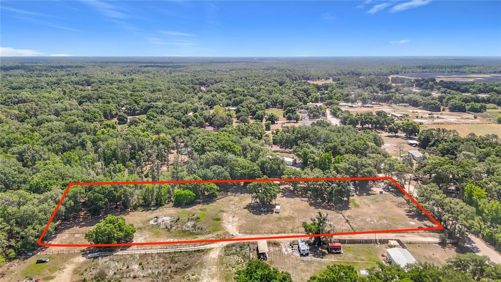 An aerial view shows a large, rectangular, fenced-in plot of land with scattered trees — 40949 JERRY ROAD, ZEPHYRHILLS, FL
