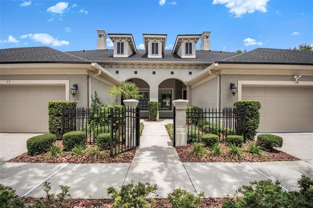 A duplex exterior features two garage doors, a central gated walkway, and three roof dormers — 19 RIVER LANDING DRIVE, PALM COAST, FL