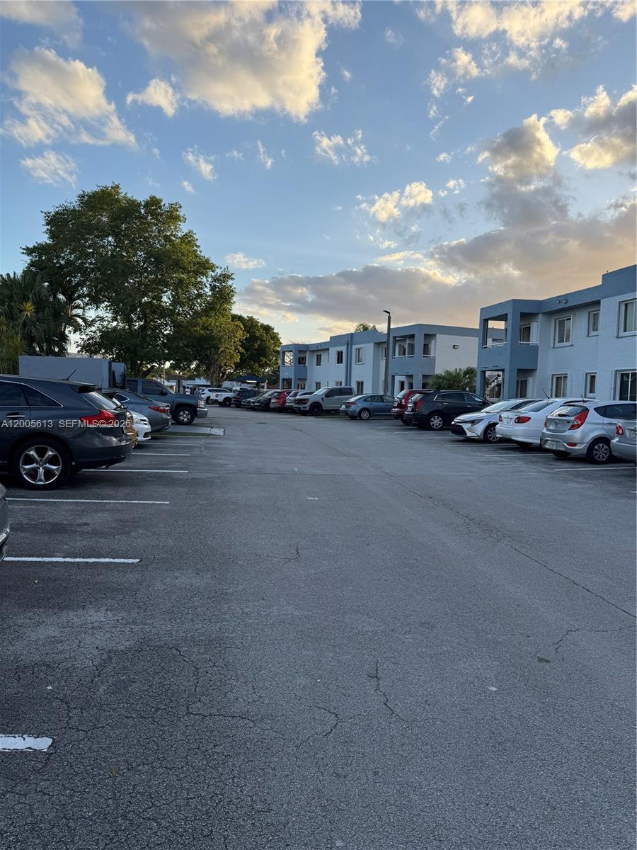 A parking lot sits in front of multi-story apartment buildings under a cloudy sky — 6219 SW 131st Pl # 204, Miami FL 33183, MIAMI, FL