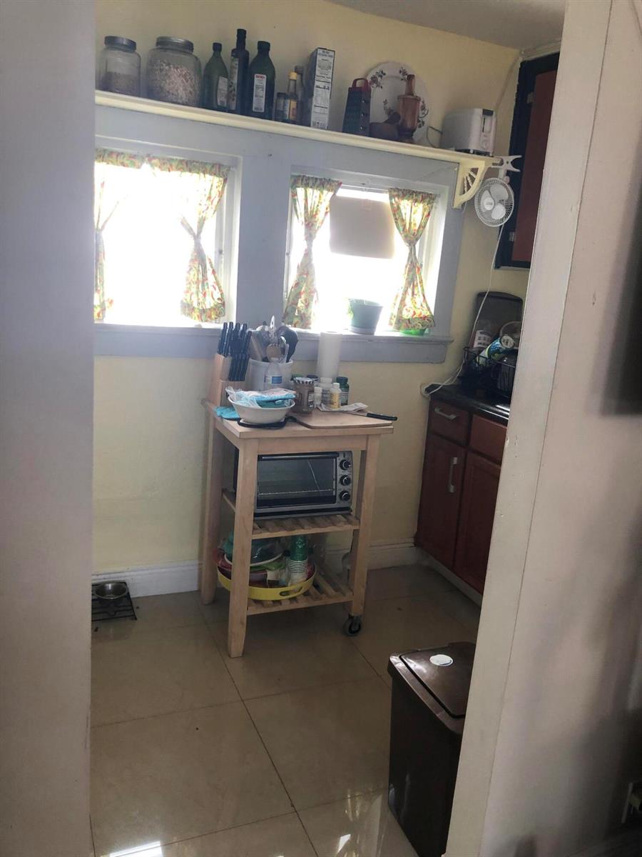A kitchen features a wooden cart, a toaster oven, and a shelf above two windows — 1021 SW 5th Street # 2, Miami FL 33130, MIAMI, FL