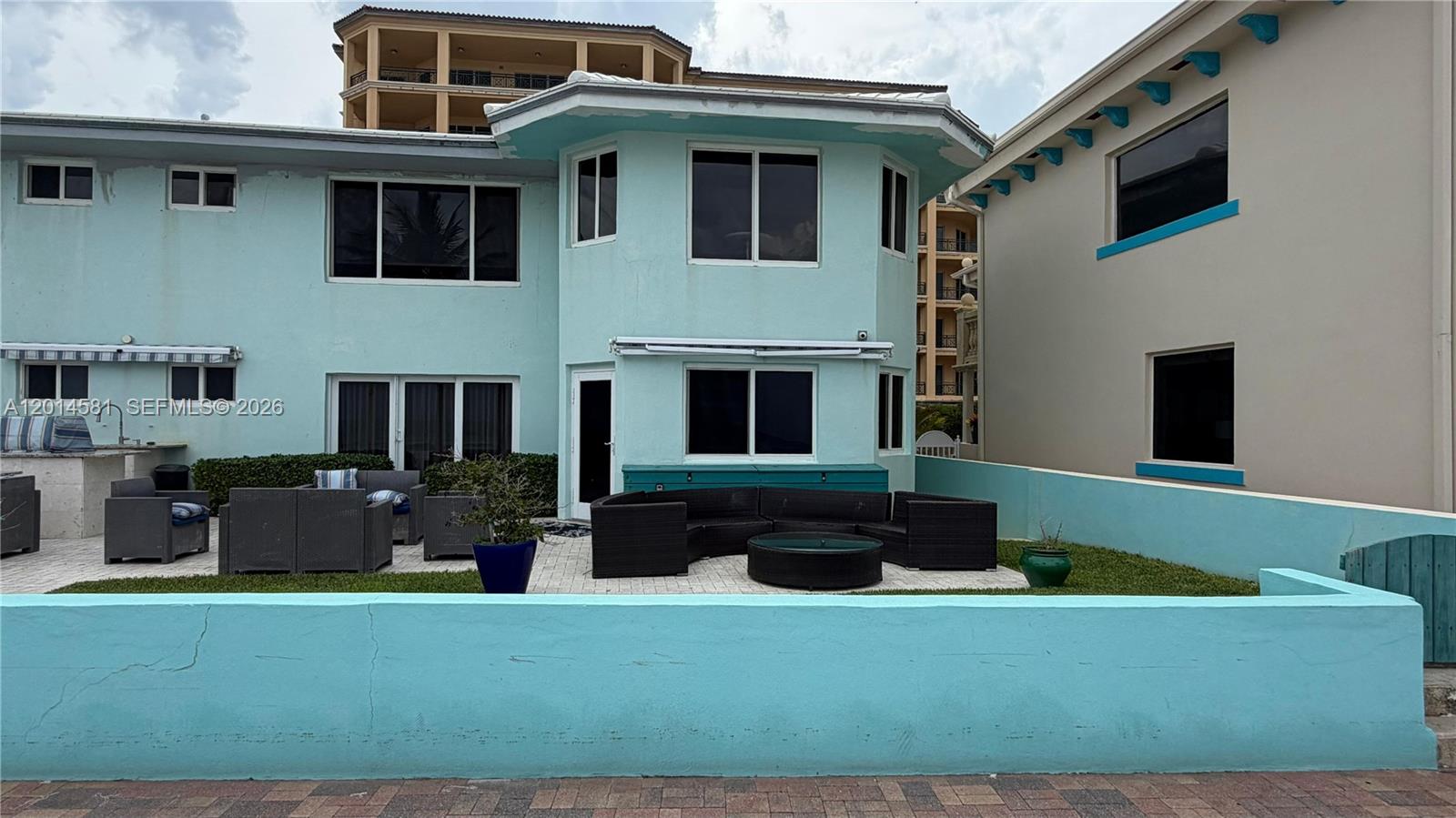 A light blue house features a patio with outdoor furniture and a low perimeter wall — 3400 N Surf Rd # 1, Hollywood FL 33019, HOLLYWOOD, FL