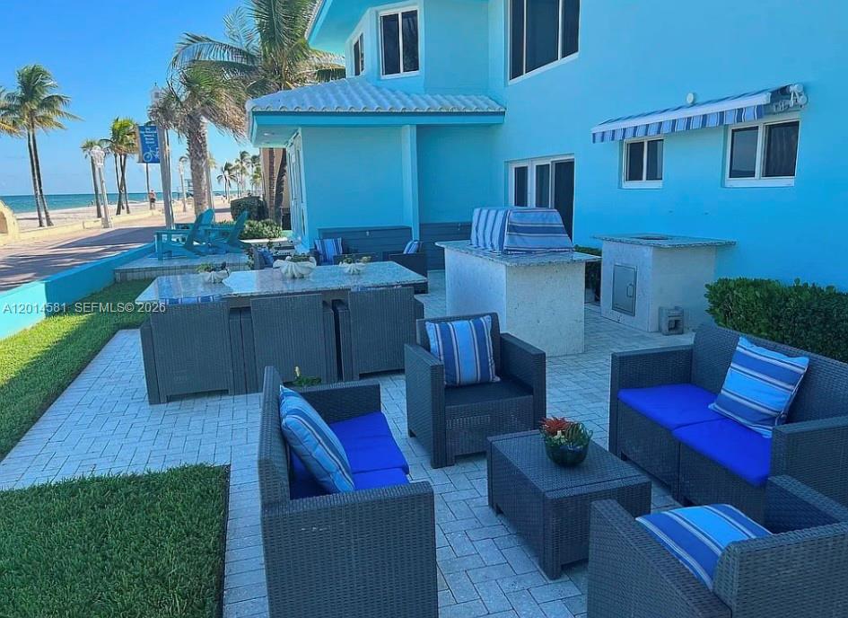 A patio area features outdoor furniture, a grill station, and a view of the beach — 3400 N Surf Rd # 1, Hollywood FL 33019, HOLLYWOOD, FL