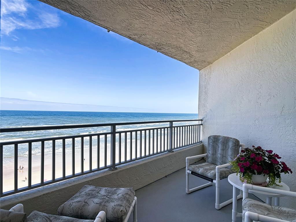 A balcony with a metal railing overlooks the ocean and beach — 5207 S ATLANTIC AVENUE UNIT 822, NEW SMYRNA BEACH, FL