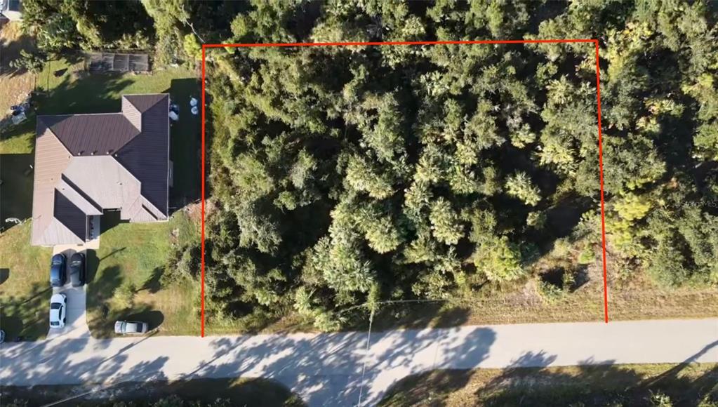An aerial view shows a wooded, rectangular vacant lot next to a house and road — Lot 5 & 6 COUNTESS AVENUE, NORTH PORT, FL